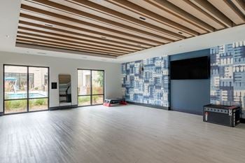 A large living room with wood floors and a large screen tv on the wall